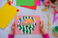 Child making homemade greeting card. little girl making basket with flowers from paper and clay,