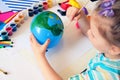 Child making planet for earth day from balloon. drawing blue ball with green continents. Protection of environment, Save our Royalty Free Stock Photo