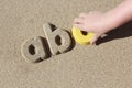 Child making sand letters on the beach
