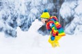 Child making snowman. Kids play in snow in winter Royalty Free Stock Photo