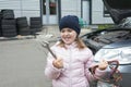 A child mechanic works in a garage, outdoors. Car repair services. Auto repair concept