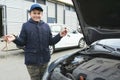 A child mechanic works in a garage, outdoors. Car repair services. Car service