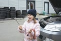 A child mechanic works in a garage, outdoors.  Car repair services.  Car service. Little girl works in the garage.  Repair service Royalty Free Stock Photo