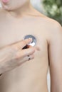 Child during medical examination in the office of a pediatrician. Medical examination with a chest stethoscope in a doctor`s offic