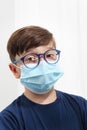 Child in a Medical Mask. Close-up portrait with a surgical mask on face isolated on white background, corona virus covid 19