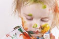 The child messy painted his face and clothes with paint. Children`s pranks