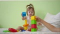 Child and mom play with colorful cubes on bed. Educational toys for preschool and kindergarten children. Toy for Kid Royalty Free Stock Photo