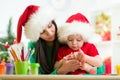 Child and mom in Santa hats making christmas tree Royalty Free Stock Photo