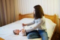 Child and mother on bed. Mom and baby boy playing in sunny bedroom. Parent and little kid relaxing at home. Family having fun Royalty Free Stock Photo