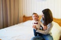 Child and mother on bed. Mom and baby boy playing in sunny bedroom. Parent and little kid relaxing at home. Family having fun Royalty Free Stock Photo