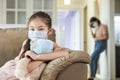 Child and mother in medical masks while coronavirus quarantined at home