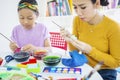 Child and mother paint Easter eggs at home