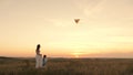 Child and mother play together and fly a kite in sky in summer outdoors. Mother and Baby, daughter are having fun in Royalty Free Stock Photo