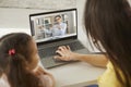 Child and mother sitting at laptop computer and listening to their online teacher Royalty Free Stock Photo