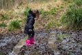Child in mud on track through woodland