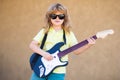 Child musician guitarist playing electric guitar. Music kids.