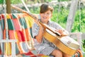 Child musician playing guitar. Kids music. Stylish little boy child wearing a summer shirt having fun on backyard. Happy Royalty Free Stock Photo