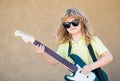 Child musician playing the guitar like a rockstar outdoor. Kid boy rock musician with guitar. Music kids. Royalty Free Stock Photo