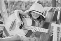 Child musician playing guitar. Stylish little child girl wearing a summer dress having fun on backyard. Summer activity Royalty Free Stock Photo