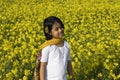 An Indian child and mustard flower in India Royalty Free Stock Photo
