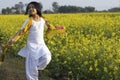 Indian girl child and mustard flower Royalty Free Stock Photo