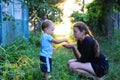 Child Nature discovery. The child throws grains of mother in hand. Photos of the child and mother, backlit Royalty Free Stock Photo