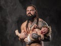 Sporty brutal man holds in arms a little baby