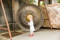 Child near Thai gong in Phuket. Tradition asian bell in Buddhism temple in Thailand. Famous Big bell wish near Gold Buddha