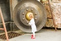 Child near Thai gong in Phuket. Tradition asian bell in Buddhism temple in Thailand. Famous Big bell wish near Gold Buddha Royalty Free Stock Photo