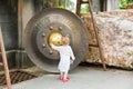 Child near Thai gong in Phuket. Tradition asian bell in Buddhism temple in Thailand. Famous Big bell wish near Gold Buddha