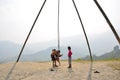 Child nepalese playing swing machine made for bamb