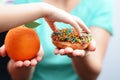 Child obesity concept with little girl hand choosing a sweet and unhealthy doughnut instead of a fruit