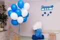 The child is one year old. Bright children`s room decorated with balloons, a toys and a large number one of colored paper.