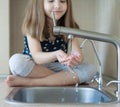 Child open water tap. Kitchen faucet. Glass of clean water. Pouring fresh drink. Hydration. Healthy lifestyle. Water quality check Royalty Free Stock Photo