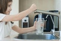 Child open water tap. Kitchen faucet. Glass of clean water. Pouring fresh drink. Hydration. Healthy lifestyle. Water quality check Royalty Free Stock Photo