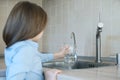 Child open water tap. Kitchen faucet. Glass of clean water. Pouring fresh drink. Hydration. Healthy lifestyle. Water quality check Royalty Free Stock Photo