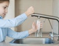 Child open water tap. Kitchen faucet. Glass of clean water. Pouring fresh drink. Hydration. Healthy lifestyle. Water quality check Royalty Free Stock Photo