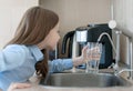 Child open water tap. Kitchen faucet. Glass of clean water. Pouring fresh drink. Hydration. Healthy lifestyle. Water quality check Royalty Free Stock Photo