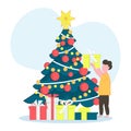 The child opening Christmas gifts for winter holidays. Christmas tree