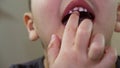 Child opening mouth and trying to remove wobbly baby tooth with tongue. Macro of dental cavity during changing milk Royalty Free Stock Photo