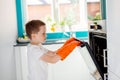 Child opening oven in kitchen.