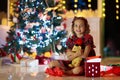 Kids at Christmas tree. Children open presents Royalty Free Stock Photo