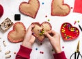 Child opens the paper heart with colorful sweets. Handmade gift with sweets for wedding, Valentine`s or Muther`s day.