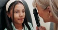 Child, optometrist and checkup for vision, health and eye care with retinoscope test. Girl, optician and technology for