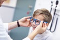 Child optometry male optometrist optician doctor examines eyesight of little boy
