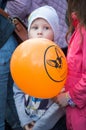 A child with orange balloon with Corgi Parade logo