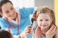 Child with otitis media attending pediatric otolaryngologist at hospital