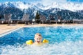 Child in outdoor swimming pool of alpine resort