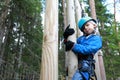 Child overcoming hanging logs obstacle in adventure park