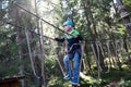 Child overcoming hanging ropes obstacle in adventure park